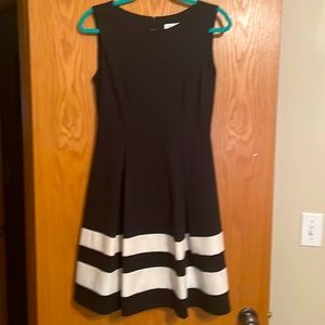 Calvin Klein black dress with two horizontal white stripes on the hen